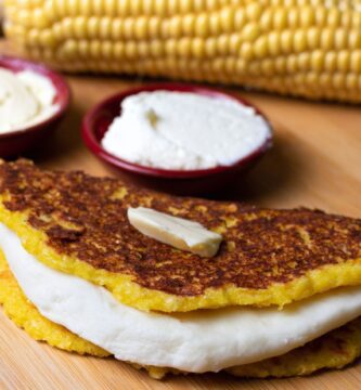 Cachapa con queso y mantequilla, junto a crema de nata