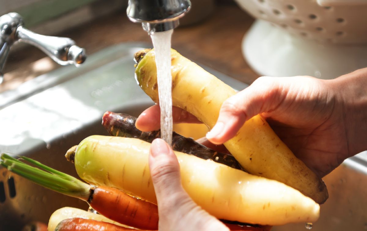 Chef limpiando vegetales en el fregadero