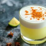 Pisco sour casero servido con rodajas de limón